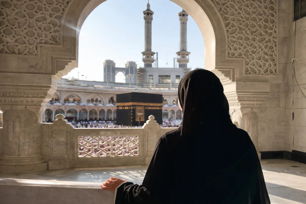 Home 54 Budget-friendly Umrah Packages Ireland – Muslim woman in black abaya overlooking the Kaaba at Masjid al-Haram in Makkah during Umrah pilgrimage.